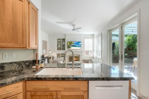 a kitchen with granite countertop a sink and white cabinets