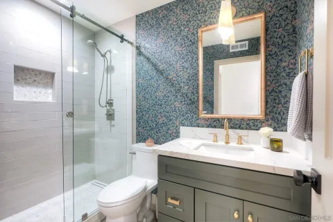a bathroom with a sink a toilet and shower