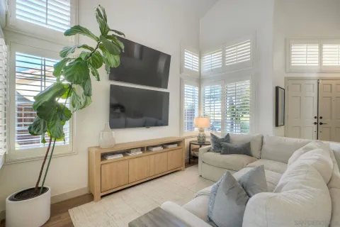 a living room with furniture a window and a potted plant