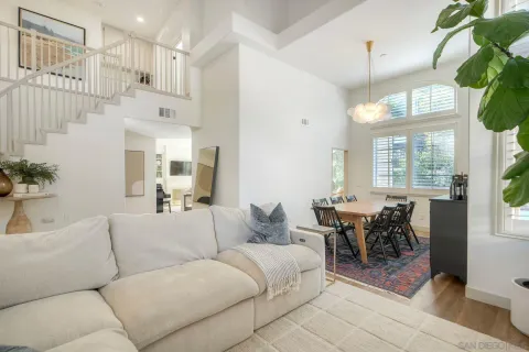 a living room with furniture a chandelier and a dining table