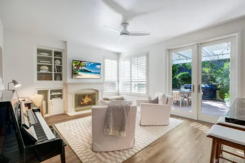 a living room with furniture a fireplace and a floor to ceiling window