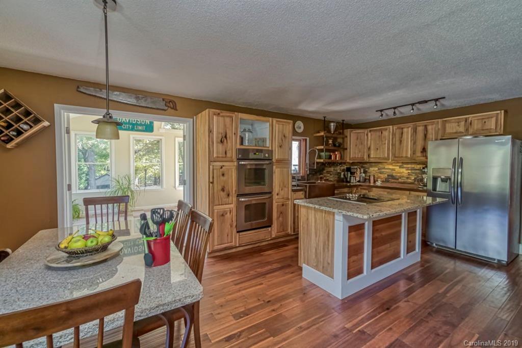 18100 Barnhardt Road Davidson, NC 28036 - Photo 10 of 29 a kitchen with stainless steel appliances wooden floor dining table and chairs