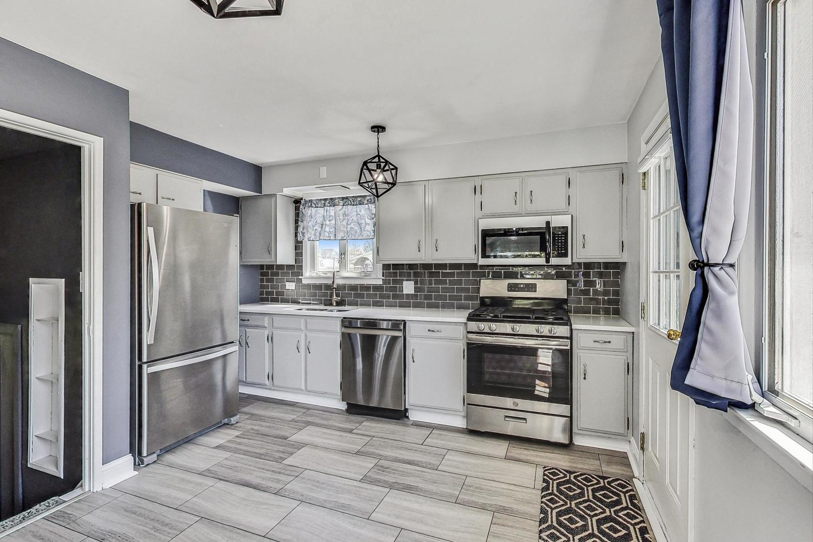 509 North Willow Road Elmhurst, IL 60126 - Photo 4 of 26 a kitchen with stainless steel appliances granite countertop a refrigerator stove and sink