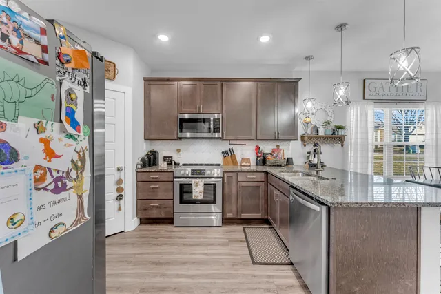 a kitchen with stainless steel appliances granite countertop a refrigerator and a stove top oven