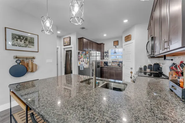 a kitchen with stainless steel appliances granite countertop a sink refrigerator and microwave