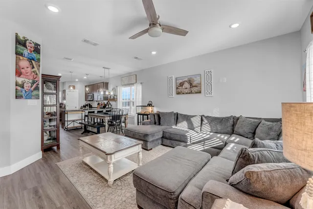 a living room with furniture and a view of kitchen
