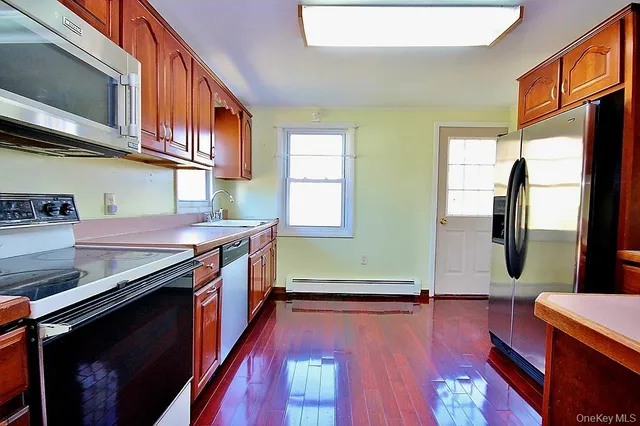 a kitchen with stainless steel appliances granite countertop a stove a sink and a refrigerator