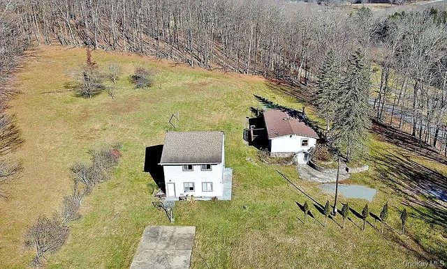 a view of a house with a yard and sitting area