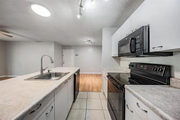 a kitchen with a sink and a stove top oven with wooden floor