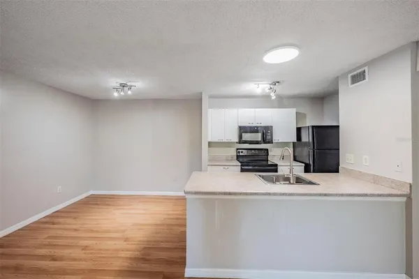 a view of kitchen with microwave and refrigerator