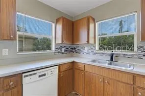 a kitchen with stainless steel appliances white cabinets a sink and a large window