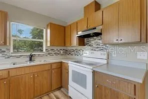 a kitchen with stainless steel appliances granite countertop a sink a stove and cabinets
