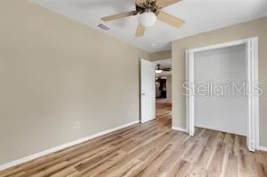 a view of a room with wooden floor and ceiling fan