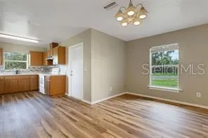 a view of a kitchen with wooden floor and a window