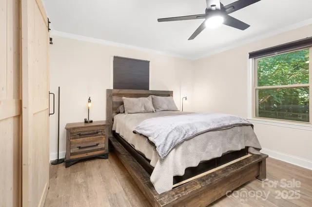 a bedroom with a bed and large windows