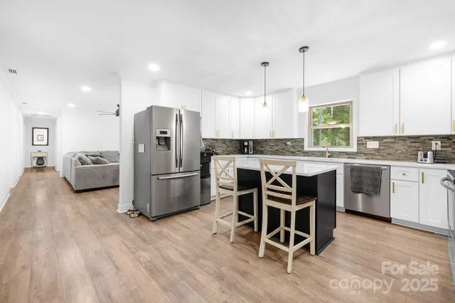 a kitchen with stainless steel appliances a stove a sink island and a refrigerator