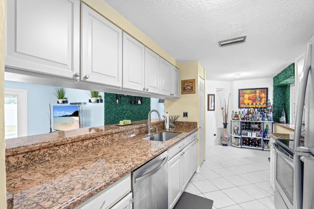 a kitchen with granite countertop a sink and a stove
