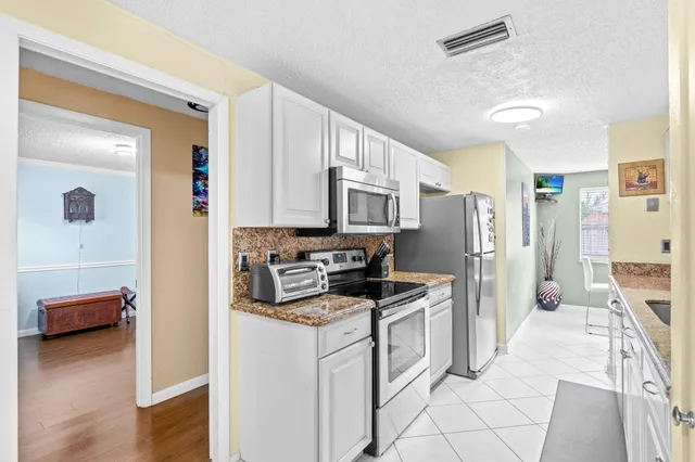 a kitchen with stainless steel appliances a refrigerator sink and cabinets