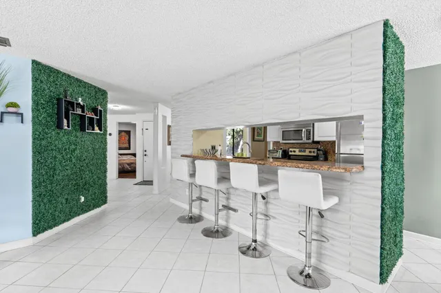 a living room with furniture a flat screen tv and kitchen view