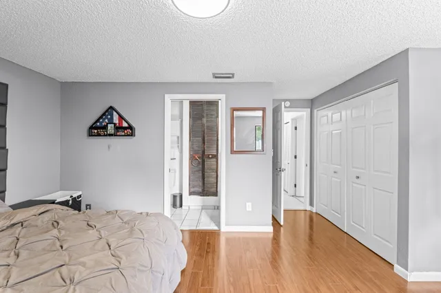 a spacious bedroom with a bed and a wooden floor