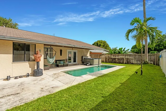 a view of a house with backyard sitting area and swimming pool