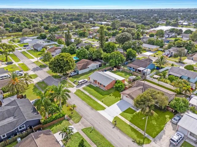 an aerial view of residential houses with outdoor space and parking