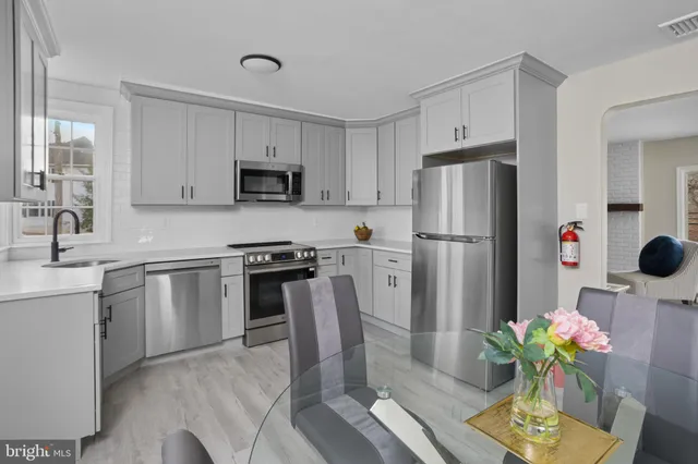 a kitchen with stainless steel appliances a stove refrigerator sink and cabinets