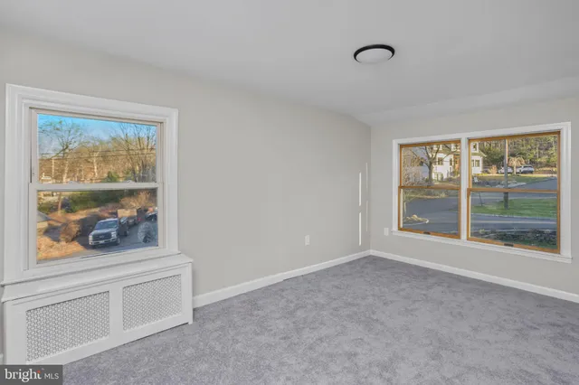 a view of an empty room with window and cabinet