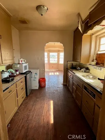 a kitchen with stainless steel appliances a stove a sink a refrigerator and wooden floor