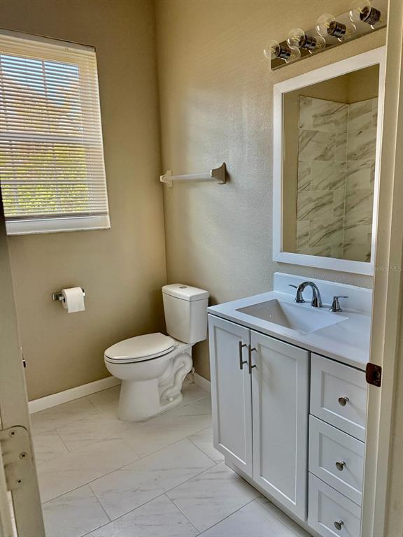 13572 Turtle Marsh Loop, Unit 212 Orlando, FL 32837 - Photo 14 of 20 a bathroom with a toilet sink vanity and mirror