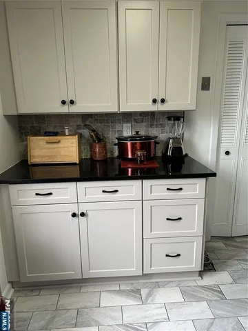 a kitchen with white cabinets and appliances