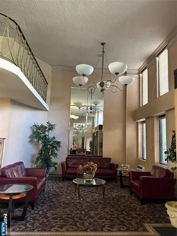 a living room with furniture chandelier and a rug