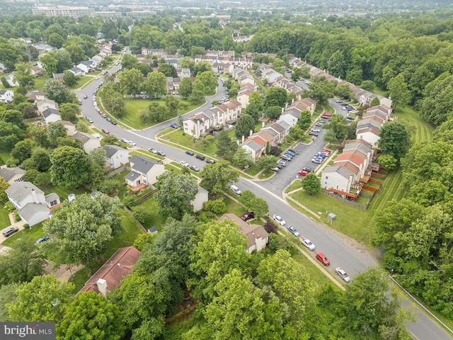 an aerial view of residential houses with outdoor space and trees