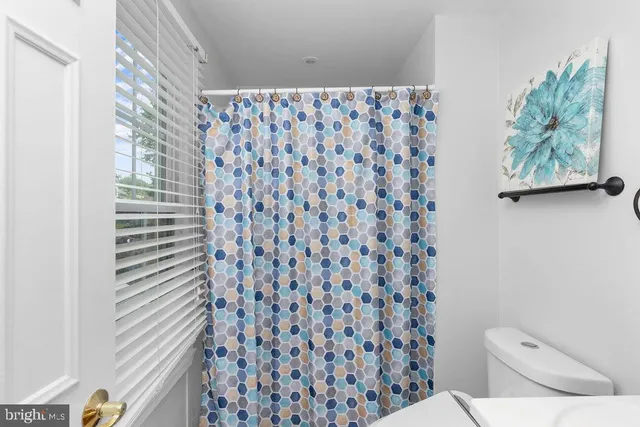 a bathroom with a toilet and a shower curtain