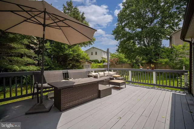 a balcony with wooden floor table and chairs