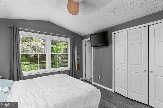 a bedroom with a bed and a large window