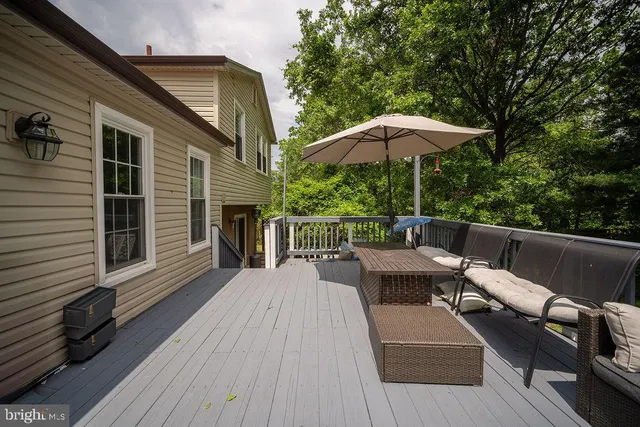 a balcony with wooden floor table and chairs