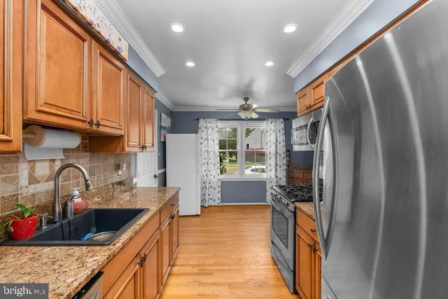a kitchen with stainless steel appliances granite countertop a refrigerator and a sink