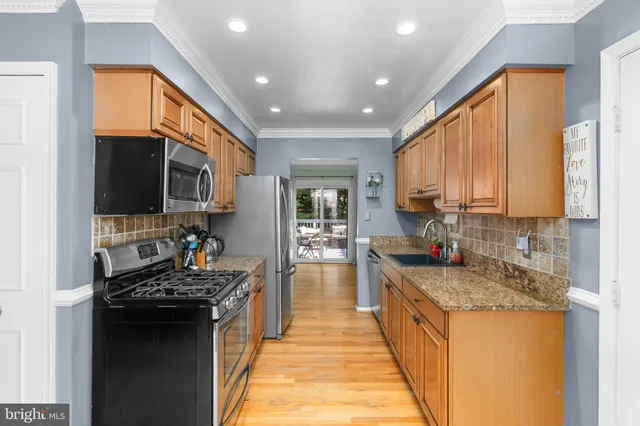 a kitchen with a sink stove top oven and refrigerator