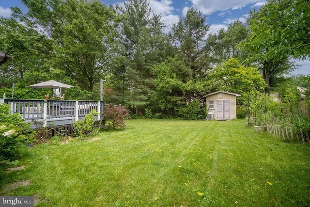 a view of a tiny house with a yard and sitting area