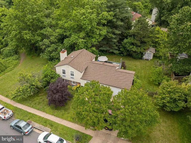 an aerial view of a house with garden space and a lake view