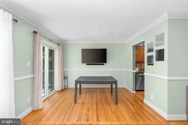 a living room with a flat screen tv and a wooden floor