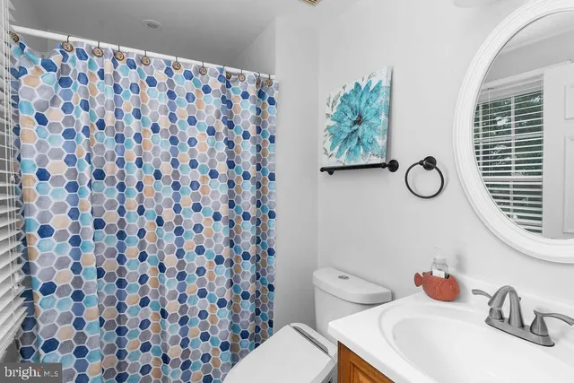 a bathroom with a granite countertop sink and a toilet