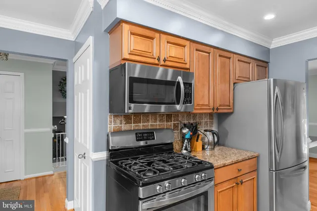 a kitchen with stainless steel appliances granite countertop a stove refrigerator and a microwave