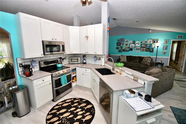 a kitchen with stainless steel appliances a stove a sink and a microwave