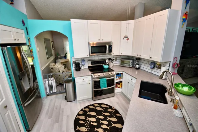 a kitchen with stainless steel appliances a stove a refrigerator and a cabinets