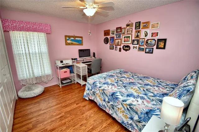 a bedroom with a bed and a chair with the bookshelf
