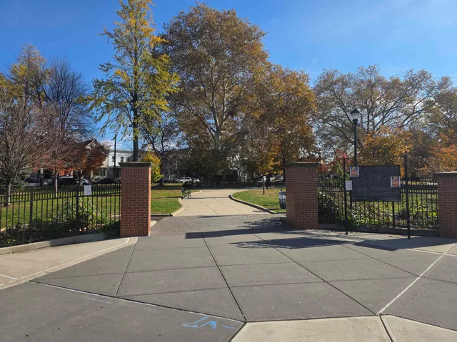 a view of swimming pool with sitting area and tree in the background