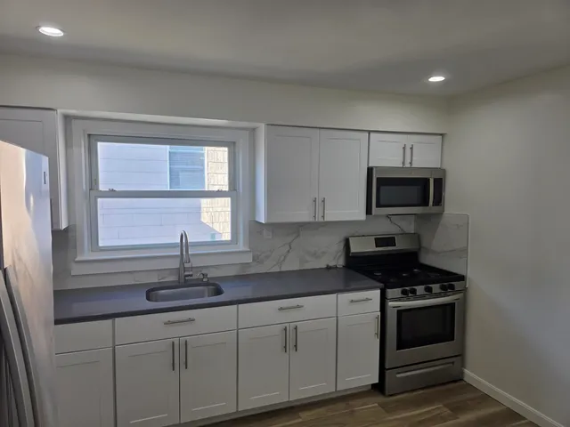 a kitchen with stainless steel appliances a sink stove and microwave