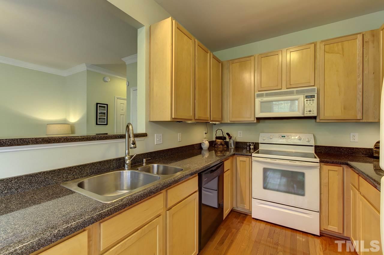 5410 Goldenglow Way Raleigh, NC 27606 - Photo 12 of 24 a kitchen with stainless steel appliances granite countertop a sink a stove and cabinets